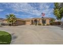 Expansive circular driveway welcomes you to this desert home showcasing lush green landscaping at 4915 N Greentree Dr, Litchfield Park, AZ 85340