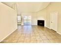 Open-concept living room with fireplace, tile flooring and sliding glass doors to the backyard at 5552 W Willow Ave, Glendale, AZ 85304