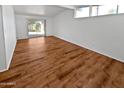 Spacious living room with hardwood floors and light paint, featuring a sliding glass door and multiple windows at 6633 W Orange Dr, Glendale, AZ 85301