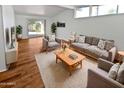 Bright living room featuring hardwood floors, neutral furniture, white brick accent wall and bright natural lighting at 6633 W Orange Dr, Glendale, AZ 85301