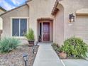 Close up of front door and walkway with desert landscaping and outdoor lighting at 6847 W Palo Brea Ln, Peoria, AZ 85383