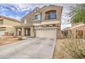 Two-story home with front porch, garage, and desert-style landscaping at 7013 W Branham Ln, Laveen, AZ 85339