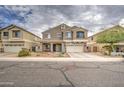 Inviting two-story home with desert landscaping, a covered front porch, and a two-car garage at 7013 W Branham Ln, Laveen, AZ 85339