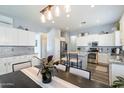 Open kitchen featuring white cabinets, stainless steel appliances, and a breakfast bar with seating for two at 7161 W Saddlehorn Rd, Peoria, AZ 85383