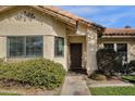 Inviting front exterior showcasing a tiled roof, manicured shrubs, and a secure screen door at 850 E Vaughn Ave, Gilbert, AZ 85234