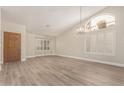 Bright living room featuring wood floors, neutral paint, vaulted ceilings, and plantation shutters at 9633 S 51St St, Phoenix, AZ 85044