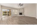 Spacious living room with wood floors, a fireplace, a ceiling fan, and sliding door access to the outdoors at 9633 S 51St St, Phoenix, AZ 85044