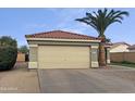 A two car garage with a beige garage door, desert landscaping, and a terracotta tile roof at 1130 S 53Rd Pl, Mesa, AZ 85206