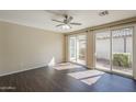 A bright and airy living room featuring dark wood flooring, a ceiling fan, and access to the outdoor patio at 1170 S Agnes Ln, Gilbert, AZ 85296