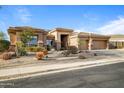 Charming single-story home featuring a three-car garage and well-maintained desert landscaping at 13018 S 177Th Ln, Goodyear, AZ 85338