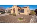 Single-story home with desert landscaping, covered entryway, and a two-car garage in a quiet neighborhood at 16038 W Acapulco Ln, Surprise, AZ 85379