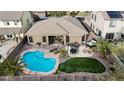 Aerial view of backyard with a pool, turf, spa, and desert landscaping, providing a private and luxurious outdoor space at 18143 W Buckhorn Dr, Goodyear, AZ 85338