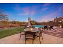 A beautifully landscaped backyard features a firepit, pool, and mountain views, perfect for outdoor entertaining at 18143 W Buckhorn Dr, Goodyear, AZ 85338
