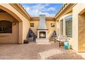 Inviting outdoor courtyard featuring a cozy fireplace, comfortable seating, and artistic decor at 18346 W Rancho Ct, Litchfield Park, AZ 85340