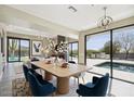 Modern dining area with pool views, stylish lighting, and an elegant table setting at 24201 N 87Th St, Scottsdale, AZ 85255