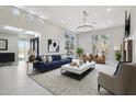Bright living room featuring a blue sofa, chandelier, and large windows with natural light at 24201 N 87Th St, Scottsdale, AZ 85255