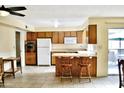 Functional kitchen with wood cabinets, breakfast bar, and adjacent dining area at 3817 W Caron St, Phoenix, AZ 85051