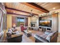 Cozy living room with a stone fireplace, wood ceiling, and ample natural light at 4115 E Ashler Hills E Dr, Cave Creek, AZ 85331