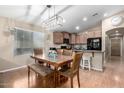 A dining area adjacent to the kitchen features an island bar and a modern light fixture at 41655 W Somerset Dr, Maricopa, AZ 85138
