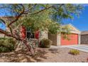 Single-story home featuring desert landscaping, a red garage door, and a tree providing shade to the house at 4402 W Bush Bean Way, San Tan Valley, AZ 85144