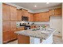 Eat-in kitchen island includes granite countertops, stainless steel appliances, and ample storage space at 4609 S 122Nd S Dr, Avondale, AZ 85323