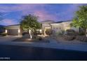 Charming home exterior featuring manicured landscaping, desert plants, and elegant lighting enhancing its curb appeal at 6514 E Crested Saguaro Ln, Scottsdale, AZ 85266