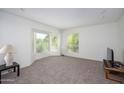 Bright living room featuring a bay window, neutral carpet, and a minimalist design at 7841 N 18Th St, Phoenix, AZ 85020
