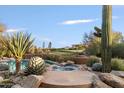 The backyard features a pool and hot tub surrounded by desert landscaping and boulders, creating an inviting outdoor oasis at 10639 E Mark Ln, Scottsdale, AZ 85262