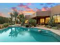 Backyard pool and desert landscaping offer a tranquil outdoor experience with access to the home's interior at 10639 E Mark Ln, Scottsdale, AZ 85262