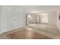 Bright foyer with a tile floor and a large white entry door, leading to a carpeted living area at 10834 N 45Th St, Phoenix, AZ 85028