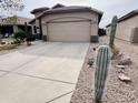 Well-maintained home with a two-car garage, desert landscaping, and a concrete driveway at 1203 W Mesquite Tree Ln, San Tan Valley, AZ 85143