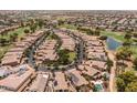 Aerial view showcasing a neighborhood with tile-roofed homes, lush landscaping, and community amenities at 14561 W Hidden Terrace Loop, Litchfield Park, AZ 85340