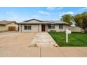 View of a well-kept single-story home with solar panels, lush grass, and a concrete driveway at 15031 N 37Th Ave, Phoenix, AZ 85053