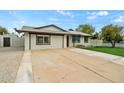 A well-maintained single-story home featuring a spacious driveway and desert landscaping at 15031 N 37Th Ave, Phoenix, AZ 85053