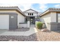 Inviting front entrance featuring a walkway leading to the front door, desert landscaping, and neutral colors at 15655 W Bethesda Ct, Surprise, AZ 85374