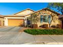 Attractive single-story home with desert landscaping, shutters, and a two-car garage at 1743 N 213Th Dr, Buckeye, AZ 85396