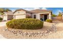 Desert landscape with a rock border surrounds the front yard at 1942 E Connemara Dr, San Tan Valley, AZ 85140