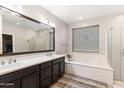 Luxurious bathroom featuring double sinks, a soaking tub, and a glass-enclosed shower at 22538 E Tierra Grande --, Queen Creek, AZ 85142