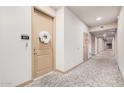Inviting hallway featuring neutral walls, patterned carpet, and a decorative wreath on a suite door at 2511 W Queen Creek Rd # 163, Chandler, AZ 85248
