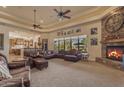 Spacious living room with stone fireplace, large windows, and views of the outdoor area at 2998 E Waterman Way, Gilbert, AZ 85297