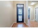 Welcoming foyer featuring a decorative security door, wood flooring, and neutral paint at 316 W Kelton Ln, Phoenix, AZ 85023