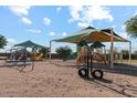 A fun community playground with shade coverings, slides, and climbing equipment at 37295 W Cannataro Ln, Maricopa, AZ 85138