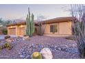 Southwest home showcasing desert landscaping with rocks and native cactus and 3 car garage at 42019 N Golf Crest Rd, Anthem, AZ 85086