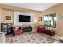 Comfortable living room featuring plush seating, a large TV, and natural light streaming through a large window at 5548 W Victory Way, Florence, AZ 85132