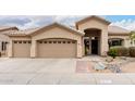 Charming single-story home showcasing desert landscaping and a three-car garage at 5670 W Irma Ln, Glendale, AZ 85308