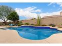 Backyard pool with a tanning ledge, desert landscaping, and outdoor seating at 5670 W Irma Ln, Glendale, AZ 85308