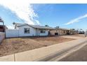 Lovely single-story home with an extended carport and desert-style landscaping at 6817 W Palm Ln, Phoenix, AZ 85035