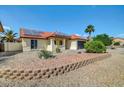 Front exterior showcasing desert landscaping, solar panels, and a low-maintenance yard at 7102 W Julie Dr, Glendale, AZ 85308