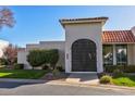 Home exterior featuring an arched gate, white brick, mature landscaping, and a tile roof at 7121 E Mcdonald Dr, Paradise Valley, AZ 85253