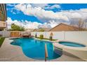 A luxurious pool with an attached hot tub and rock waterfall creates a perfect outdoor retreat at 714 W Desert Hills Dr, San Tan Valley, AZ 85143